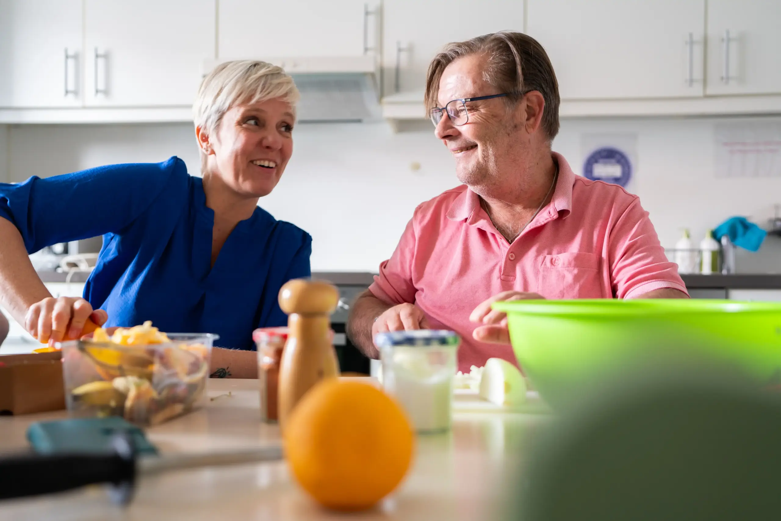 Ein Mann und eine Frau sitzen an einem Tisch. Sie unterhalten sich und lachen.