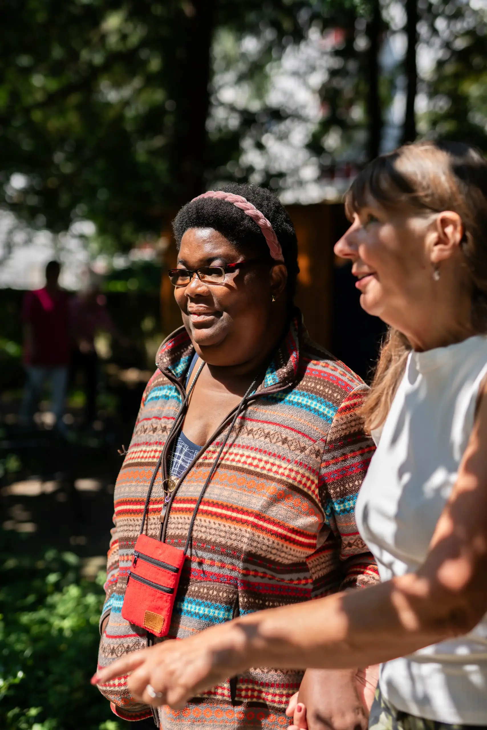 Zwei Frau stehen nebeneinander und halten Hände. Sie reden miteinander.