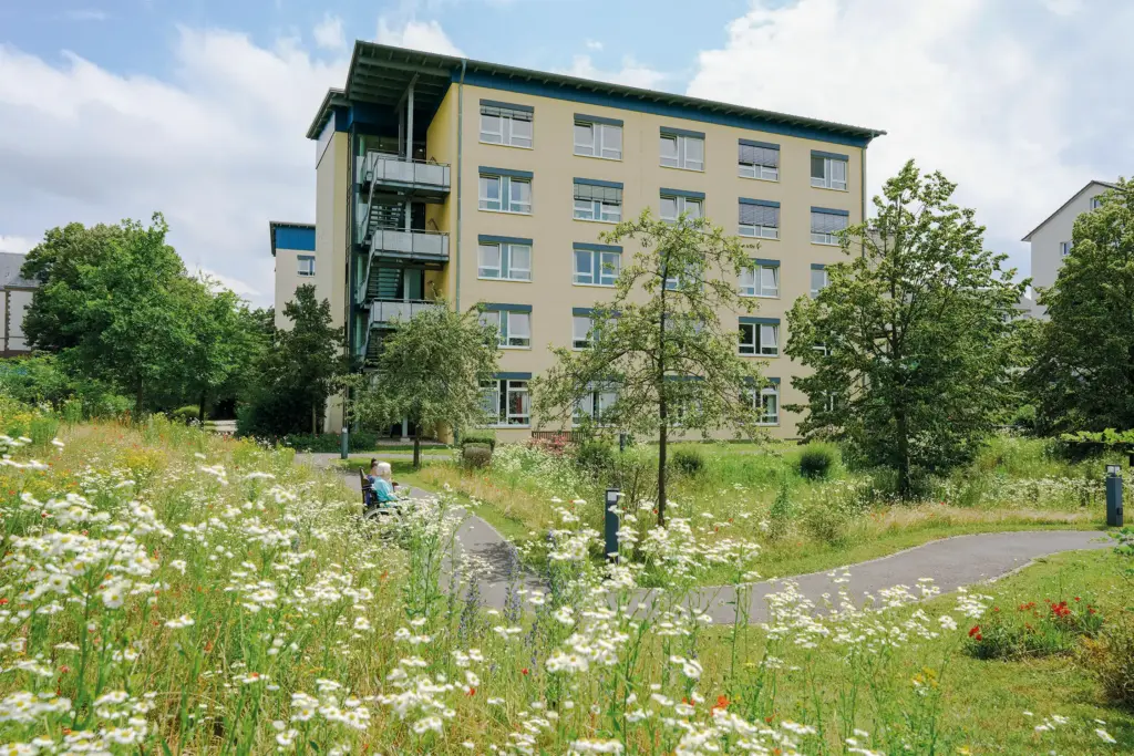 Zwei Frauen sitzen auf einer Bank hinter dem Haus Karlsruher Weg.