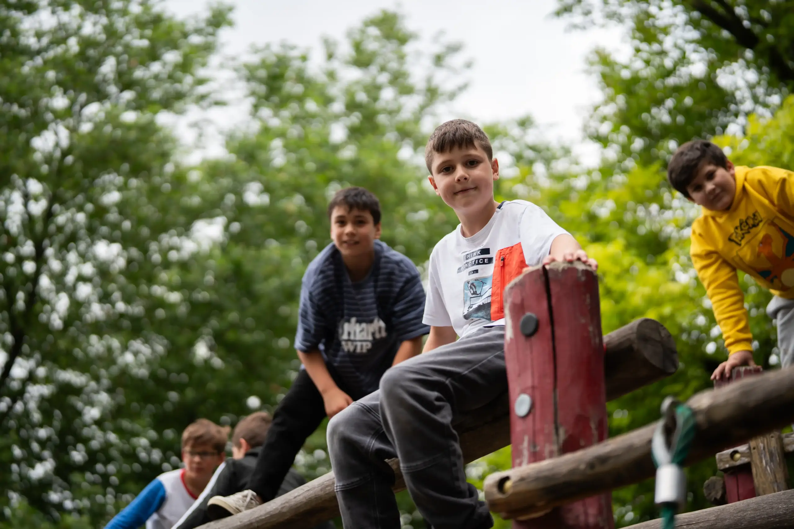 Fünf Jungen sitzen auf einem Klettergerüst. Sie schauen in die Kamera und lächeln.