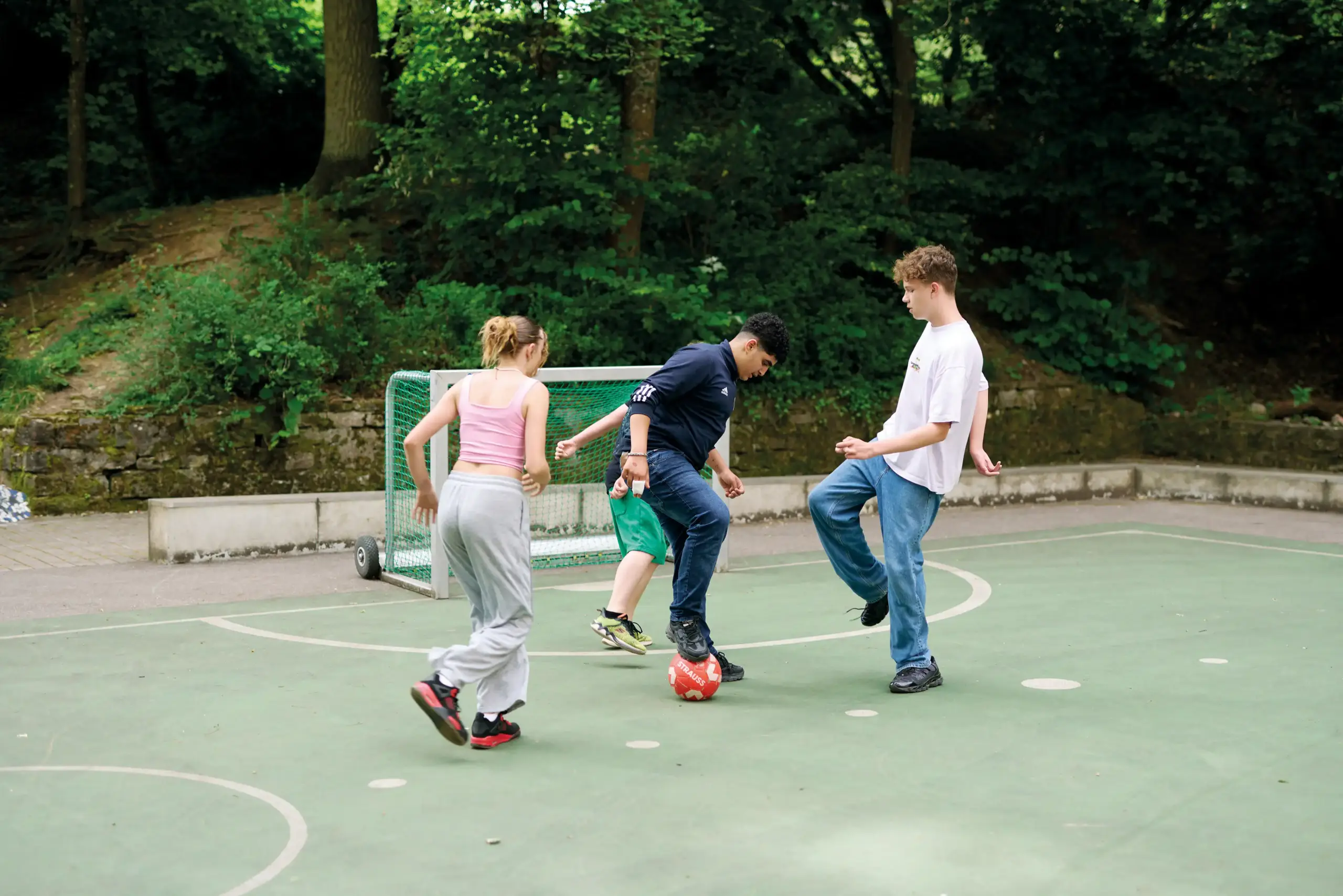 Vier Jugendliche spielen zusammen Fußball.