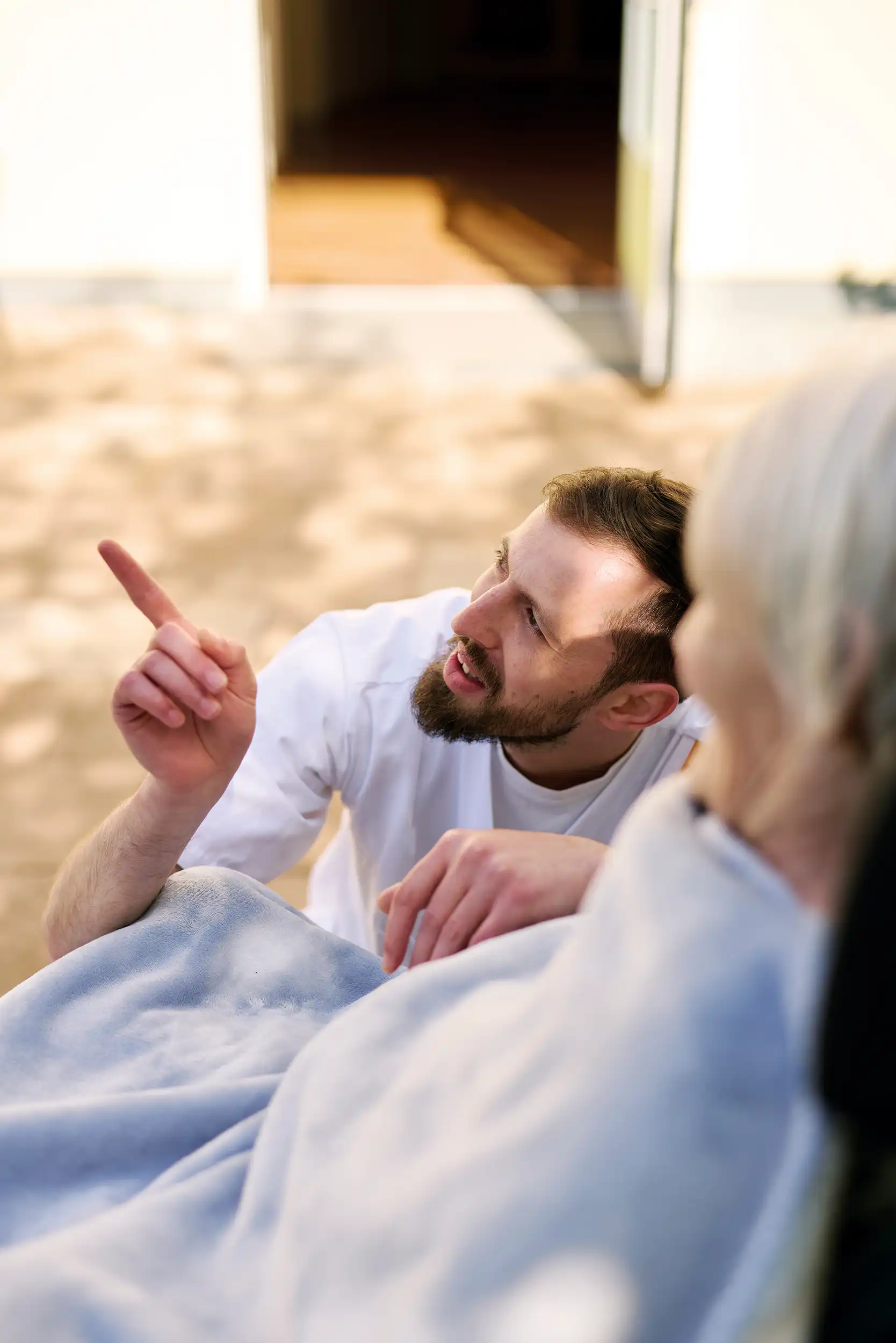 Quelle: BLV Ein Mann kniet vor einer älteren Frau. Er zeigt mit dem Finger in die Ferne, beiden schauen in diese Richtung.