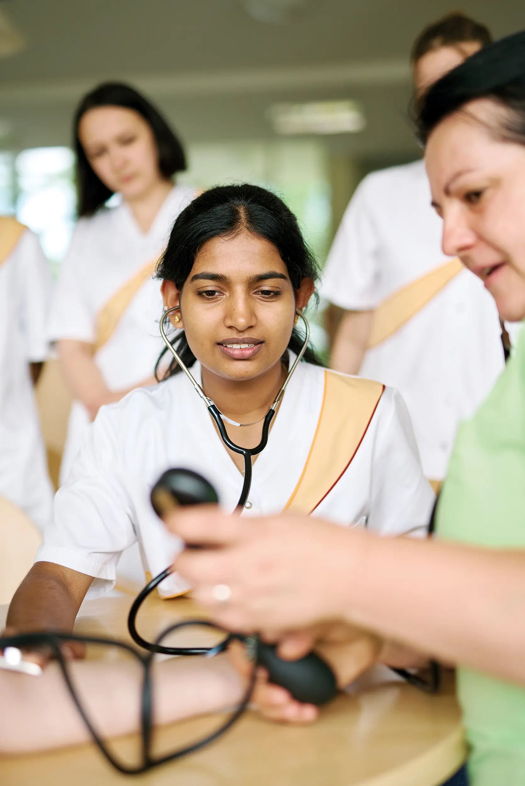 Eine Frau erklärt mehreren jungen Frauen die Funktion von medizinischen Handgeräten.