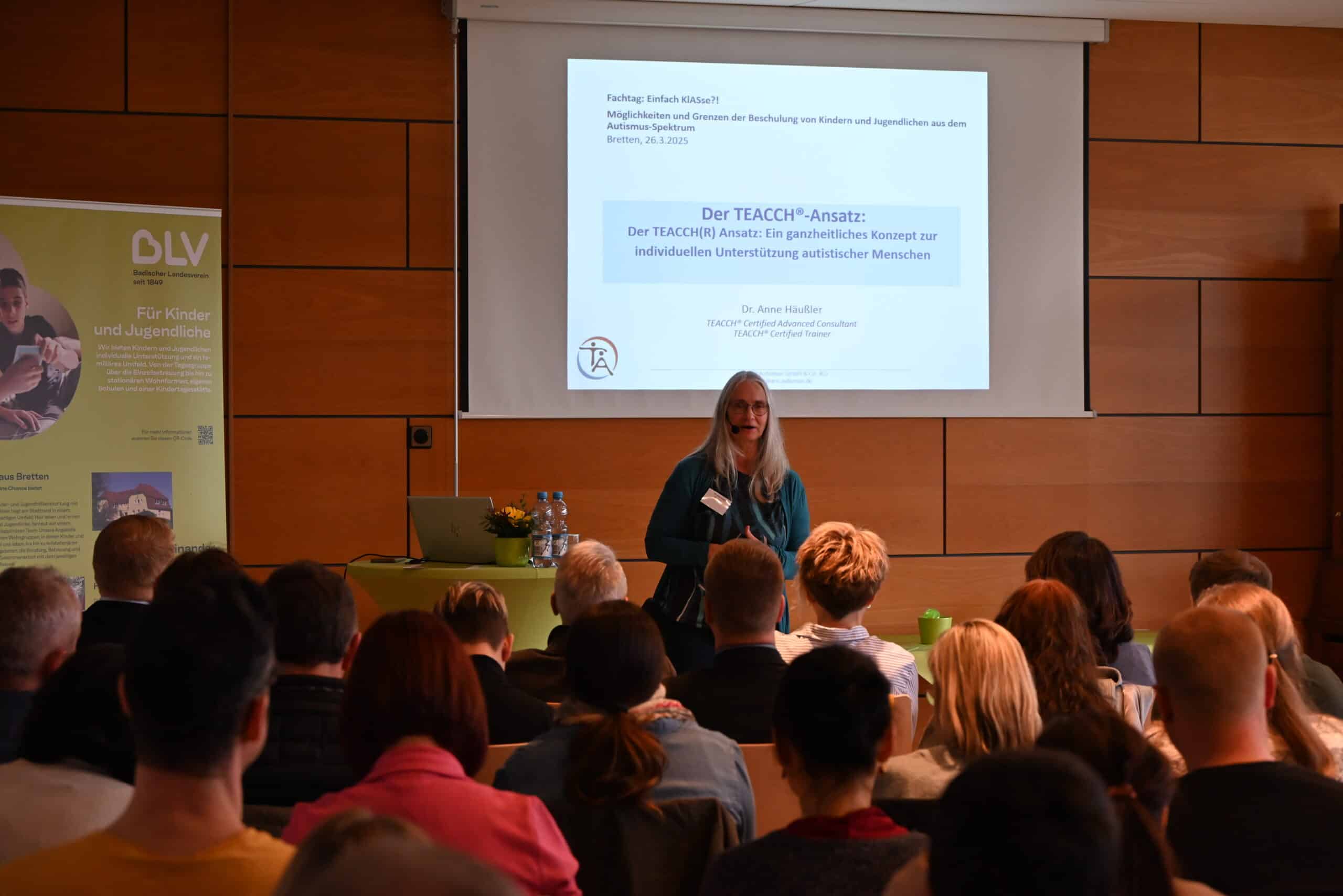 Dr. Anne Häußler steht vor einem Publikum und hält anlässlich des 