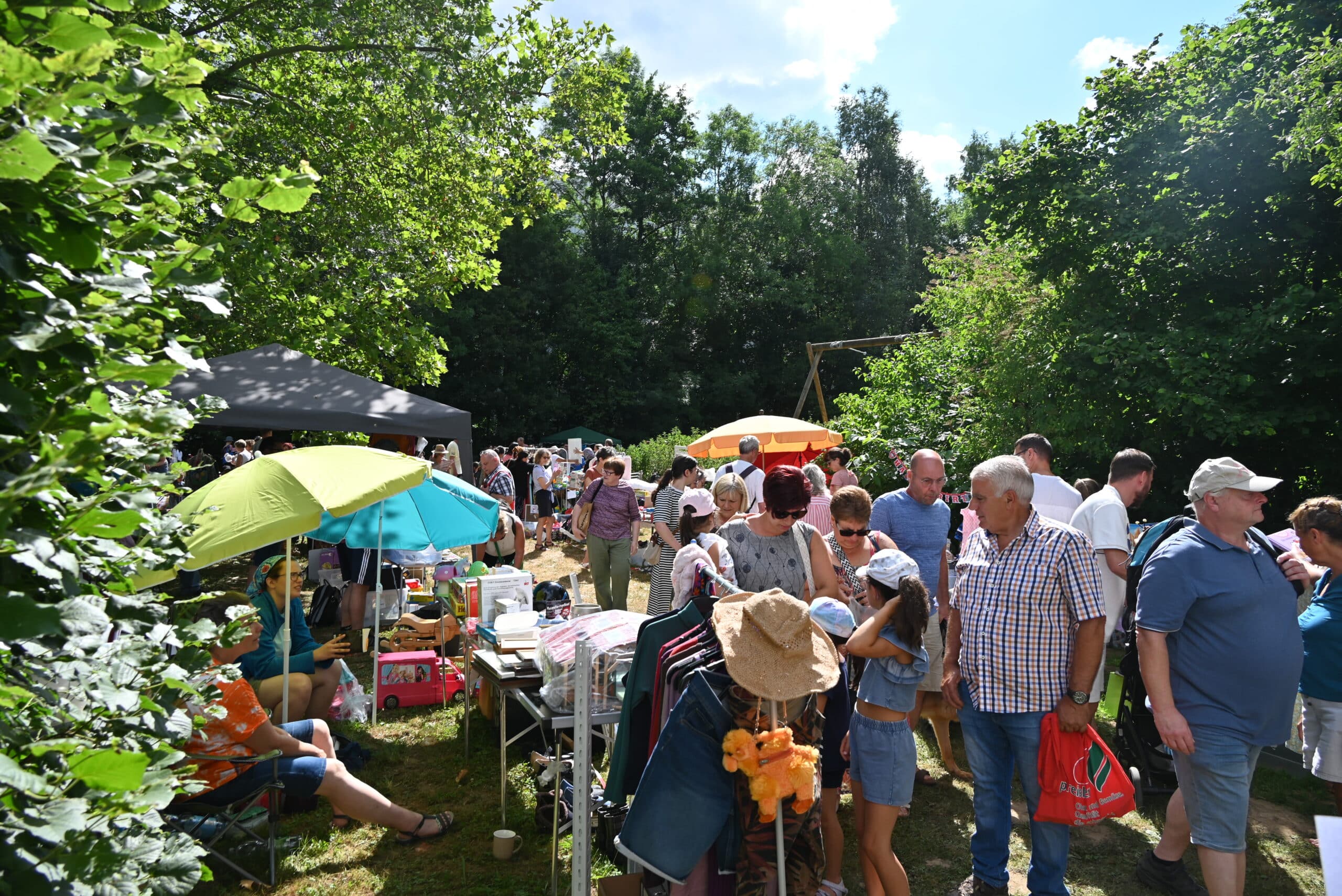 Viele Personen schlendern an den verschiedenen Ständen auf dem Hohberghaus-Flohmarkt vorbei und betrachten die Auslage.