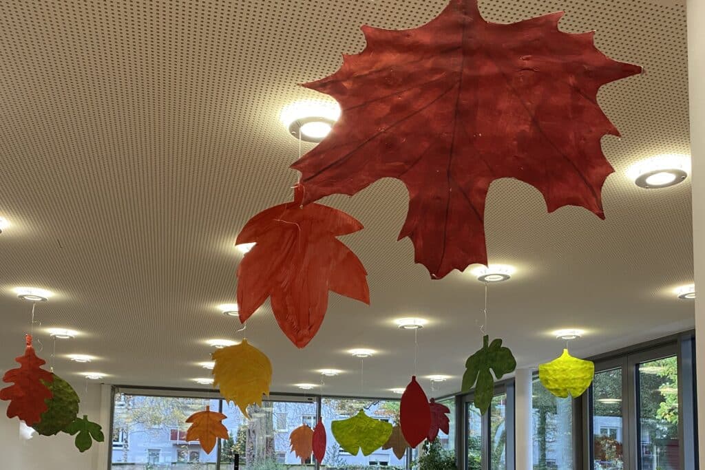 Bunte Blätter sind an Schnüren an der Decke aufgehängt.