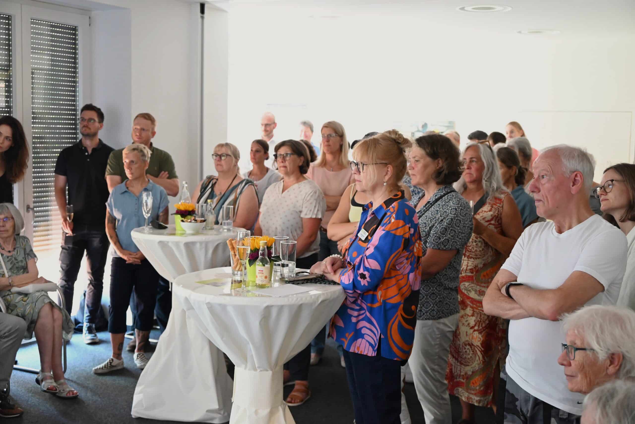 Die Besuchenden hören der Ansprache von Katharina Beckmann zu